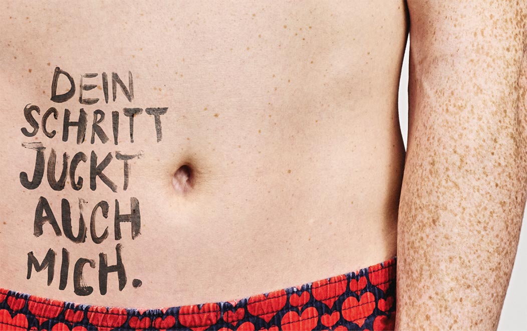 Eine Person mit Sommersprossen, auf deren Bauch der Text "Dein Schritt juckt auch mich." steht